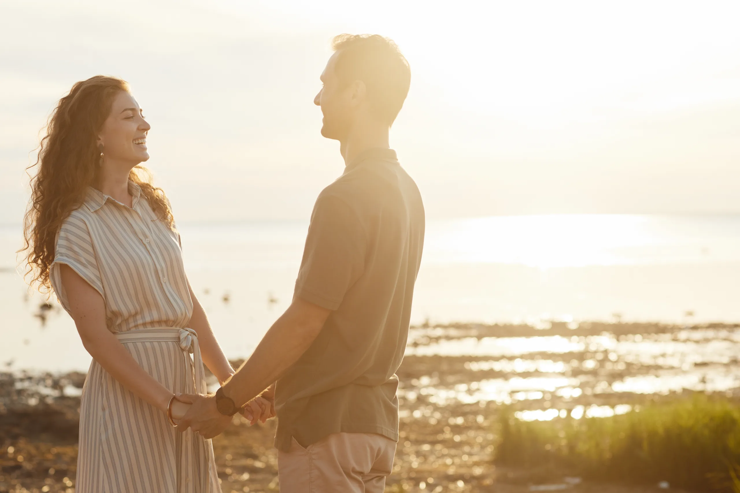 A couple holding hands outdoors at sunset