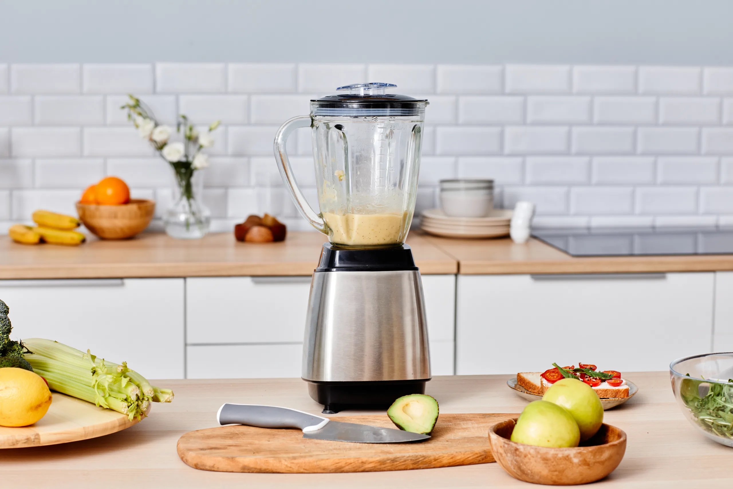 Fresh ingredients and a blender on a kitchen bench